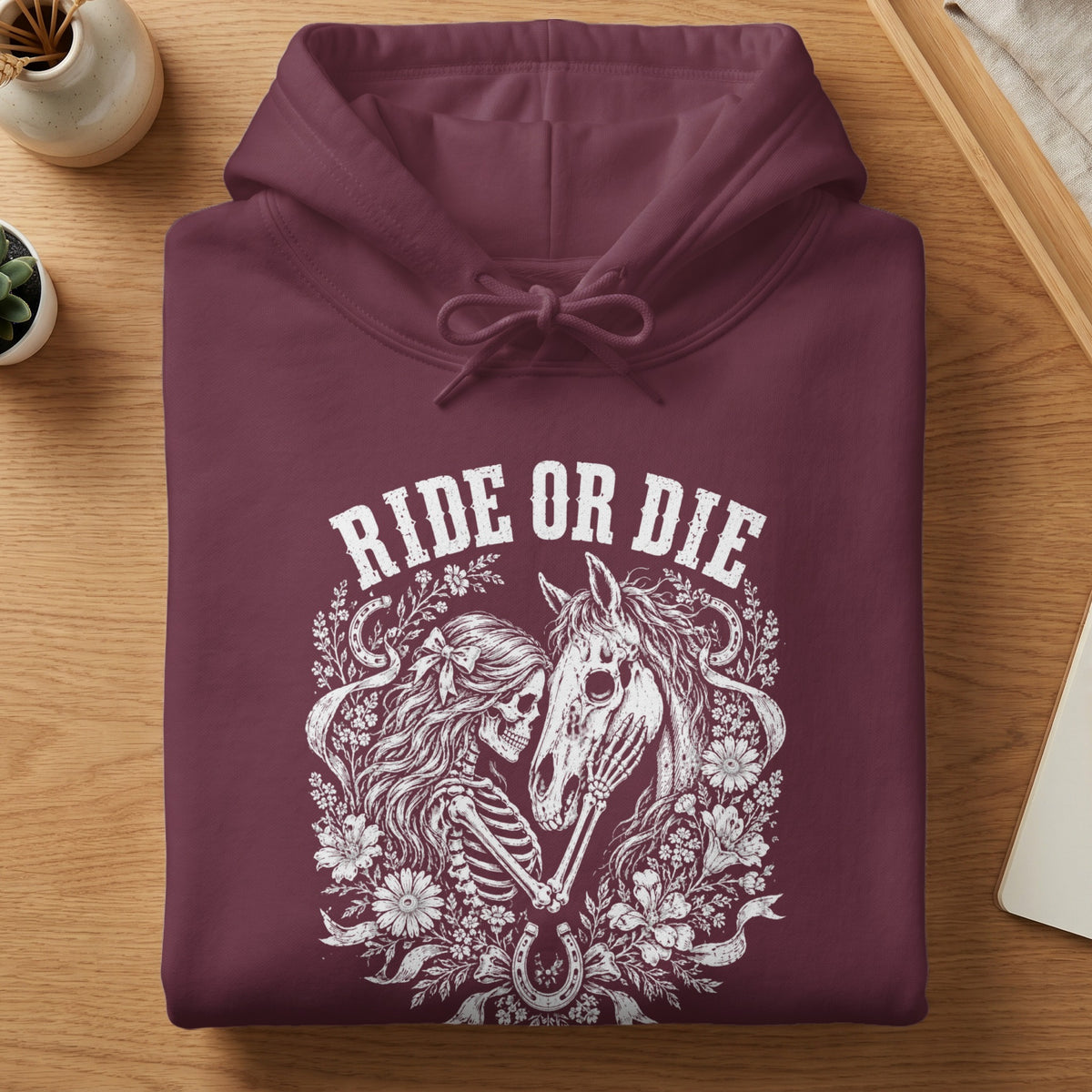 Maroon hoodie with white "Ride or Die" text, skeleton, horse, and floral graphic.