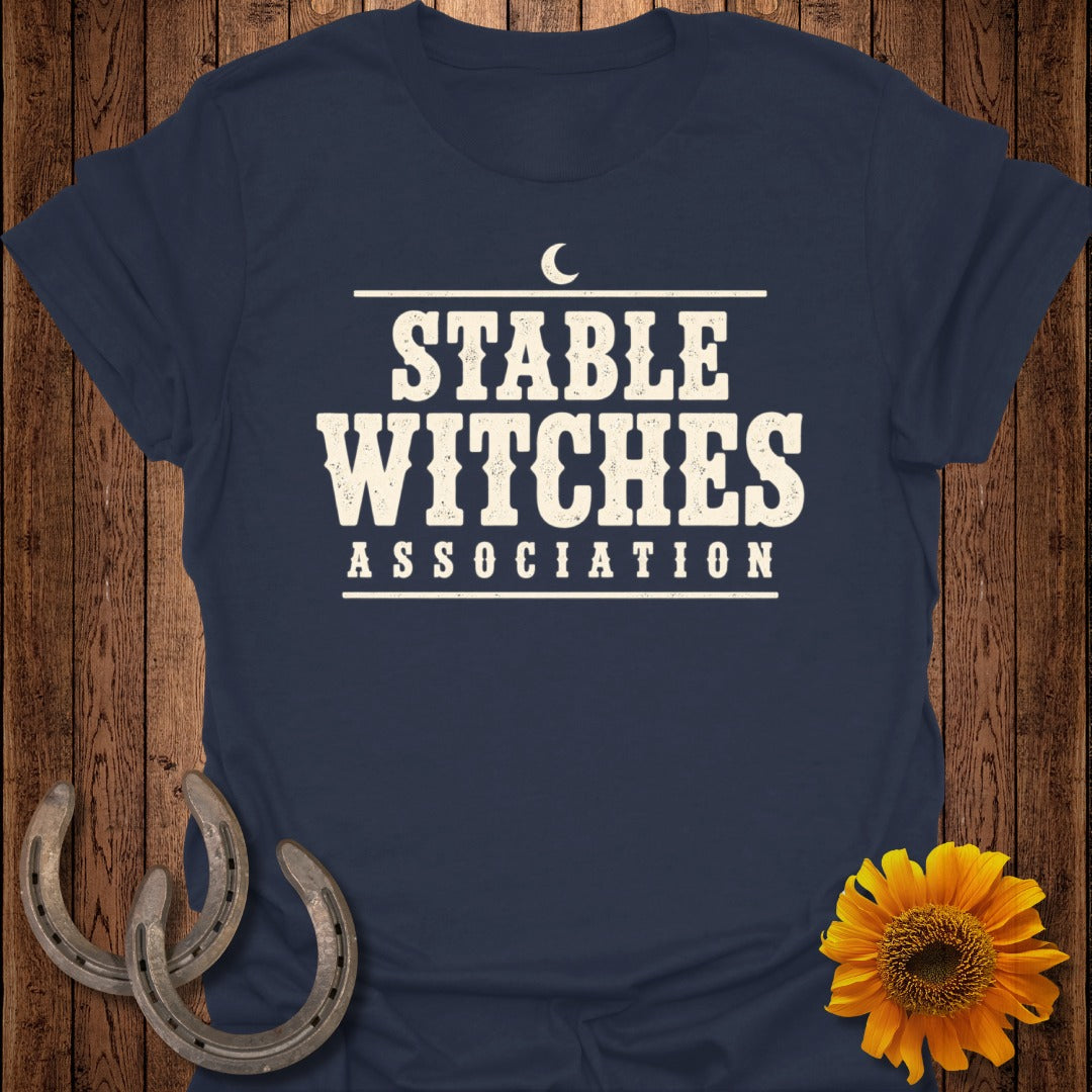 Navy t-shirt with distressed text "STABLE WITCHES ASSOCIATION" and a crescent moon.