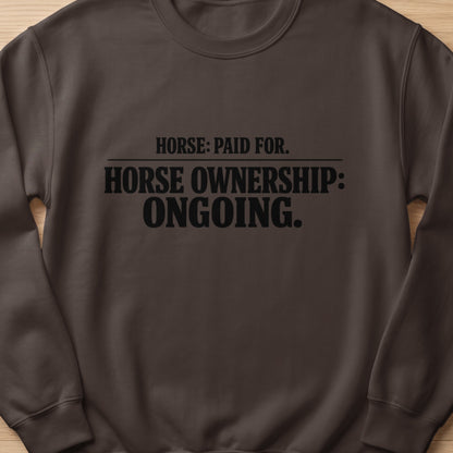 Brown sweatshirt with "Horse: Paid For. Horse Ownership: Ongoing." text.