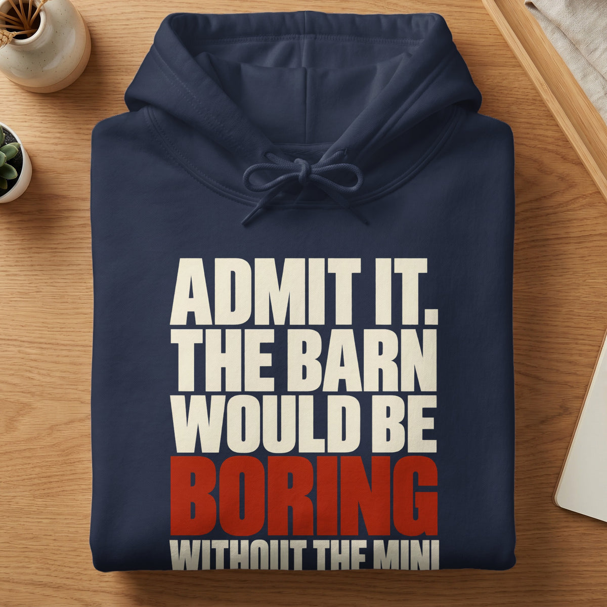A folded dark blue hoodie with white and red text reading ADMIT IT. THE BARN WOULD BE BORING WITHOUT THE MINI.