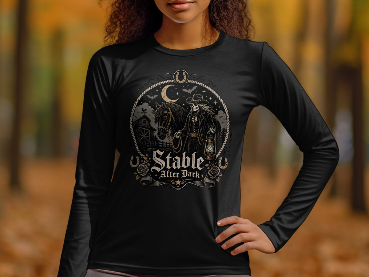 Black long-sleeve shirt with "Stable After Dark" graphic of a skeleton cowboy, horse, and barn.