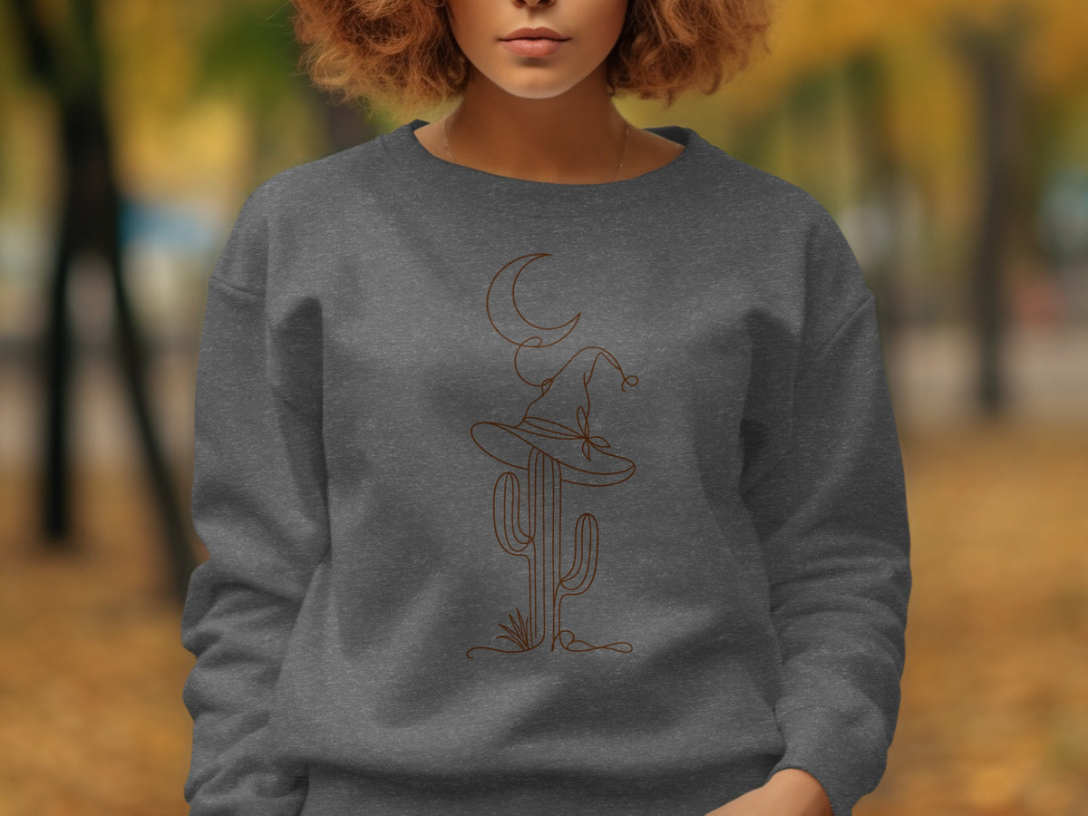 Dark gray sweatshirt with line art of a cactus, witch hat, and crescent moon.