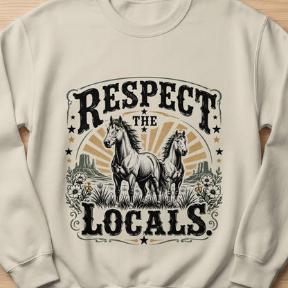 Two horses stand in a desert landscape with text that reads "RESPECT THE LOCALS."