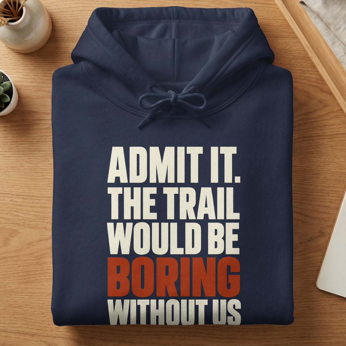 Folded dark blue hoodie with white and red text reading Admit it. The trail would be boring without us.