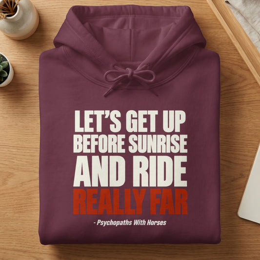 A neatly folded maroon hoodie featuring white and red text stating, Let's get up before sunrise and ride really far, - Psychopaths With Horses.