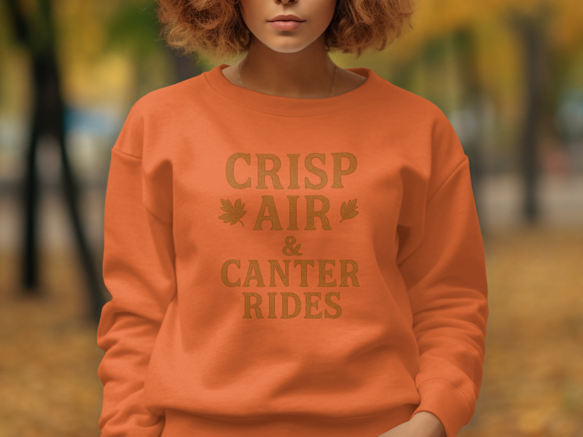 Orange sweatshirt with text "CRISP AIR & CANTER RIDES" and leaf graphics.