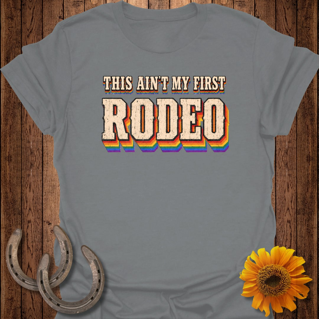 Grey t-shirt with rainbow text "THIS AIN'T MY FIRST RODEO".
