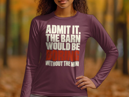 A person wearing a maroon long-sleeve shirt with white and red text stating admit it the barn would be boring without the mini.