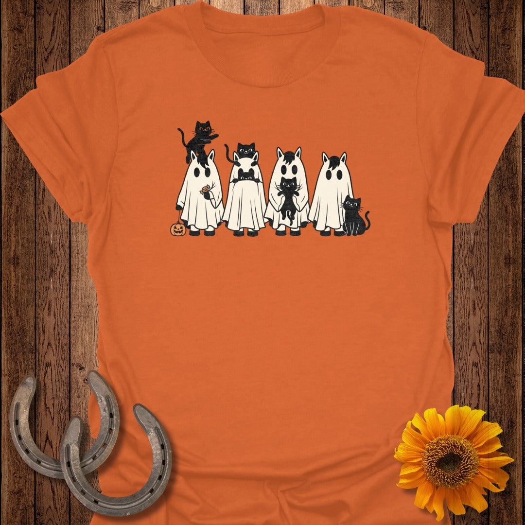 Black cats on white ghost figures with pumpkin accents on orange shirt.