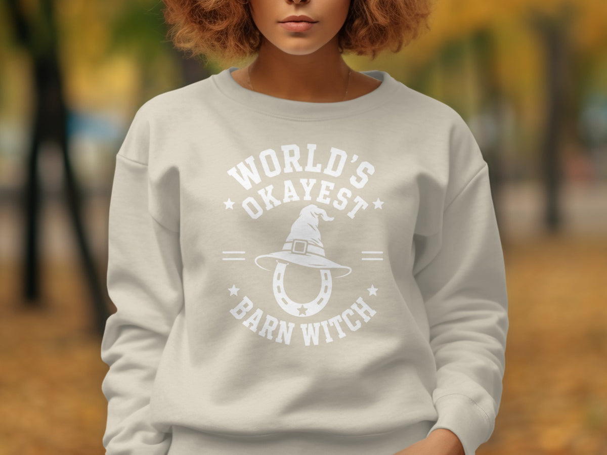 Light tan crewneck sweatshirt with white text and graphic of witch hat over horseshoe.