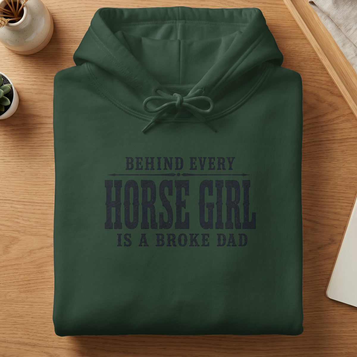 Dark green hoodie with "Behind Every Horse Girl Is A Broke Dad" text.