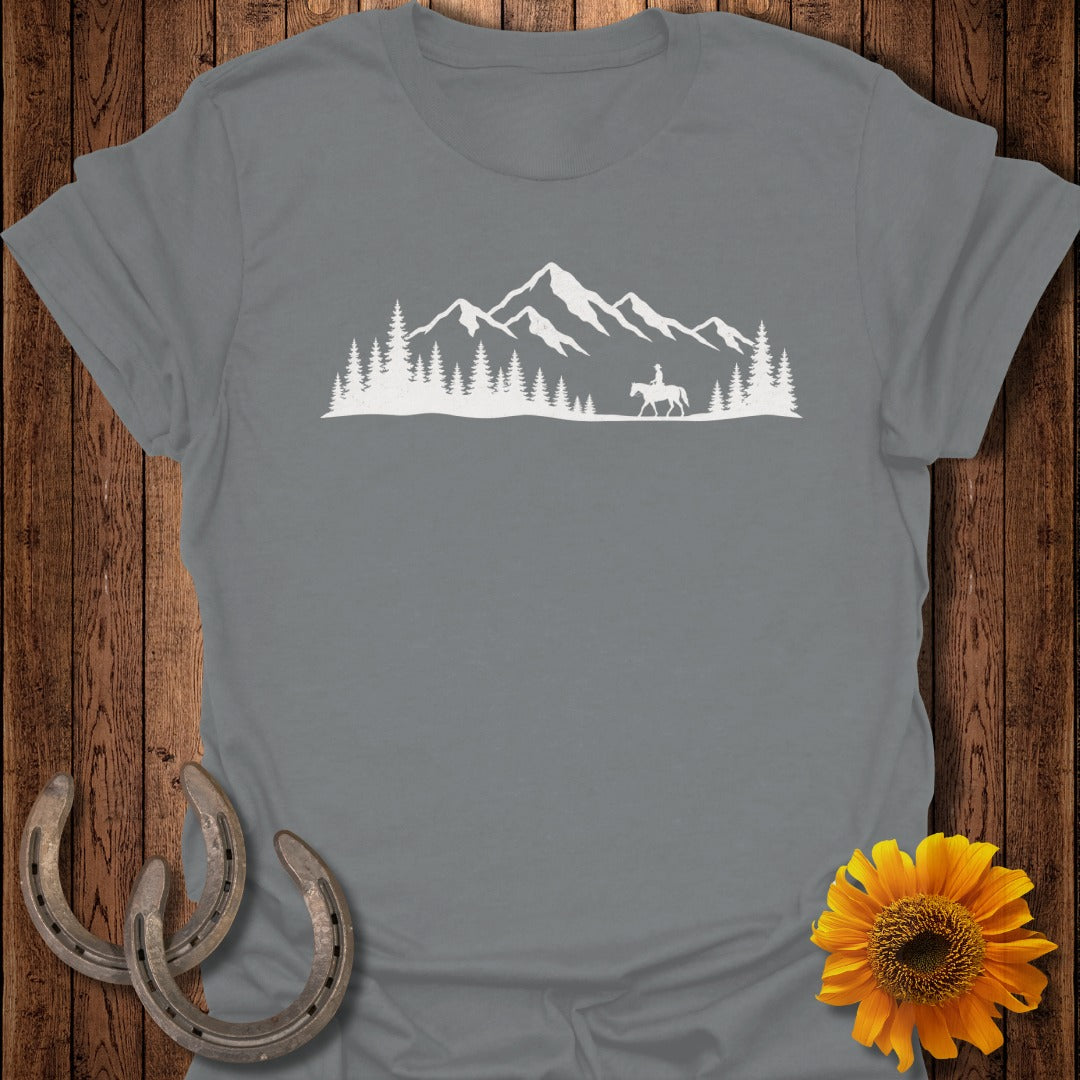 Gray t-shirt with white mountain and rider silhouette and pine trees.