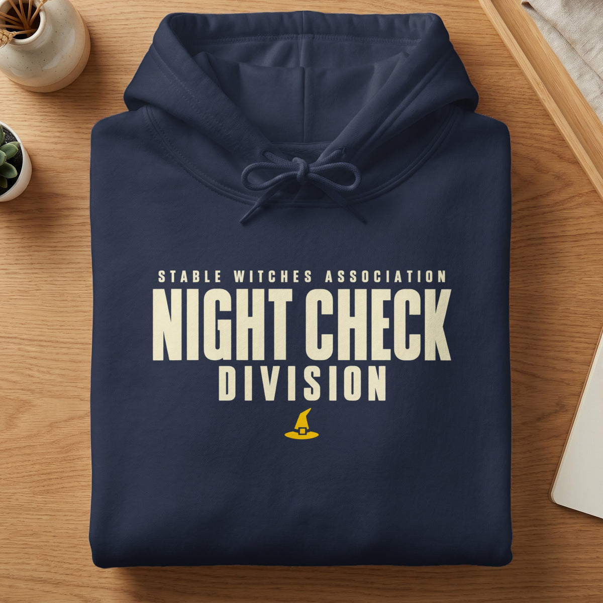 Navy hoodie with "Stable Witches Association Night Check Division" text and witch hat graphic.