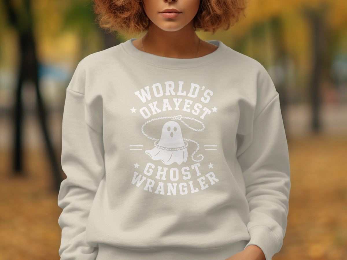 Light beige sweatshirt with white graphic of ghost and text "World's Okayest Ghost Wrangler".