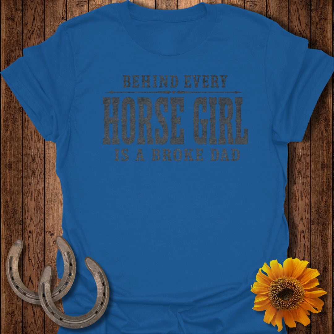 Blue t-shirt with text "BEHIND EVERY HORSE GIRL IS A BROKE DAD."