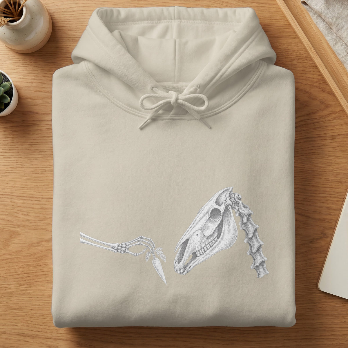 Light beige hoodie with a skeletal horse head and hand offering a carrot design.