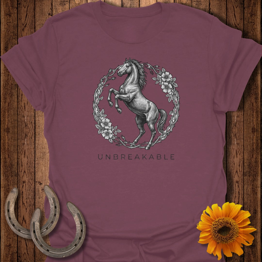 T-shirt with a rearing horse inside a floral wreath, text UNBREAKABLE below.