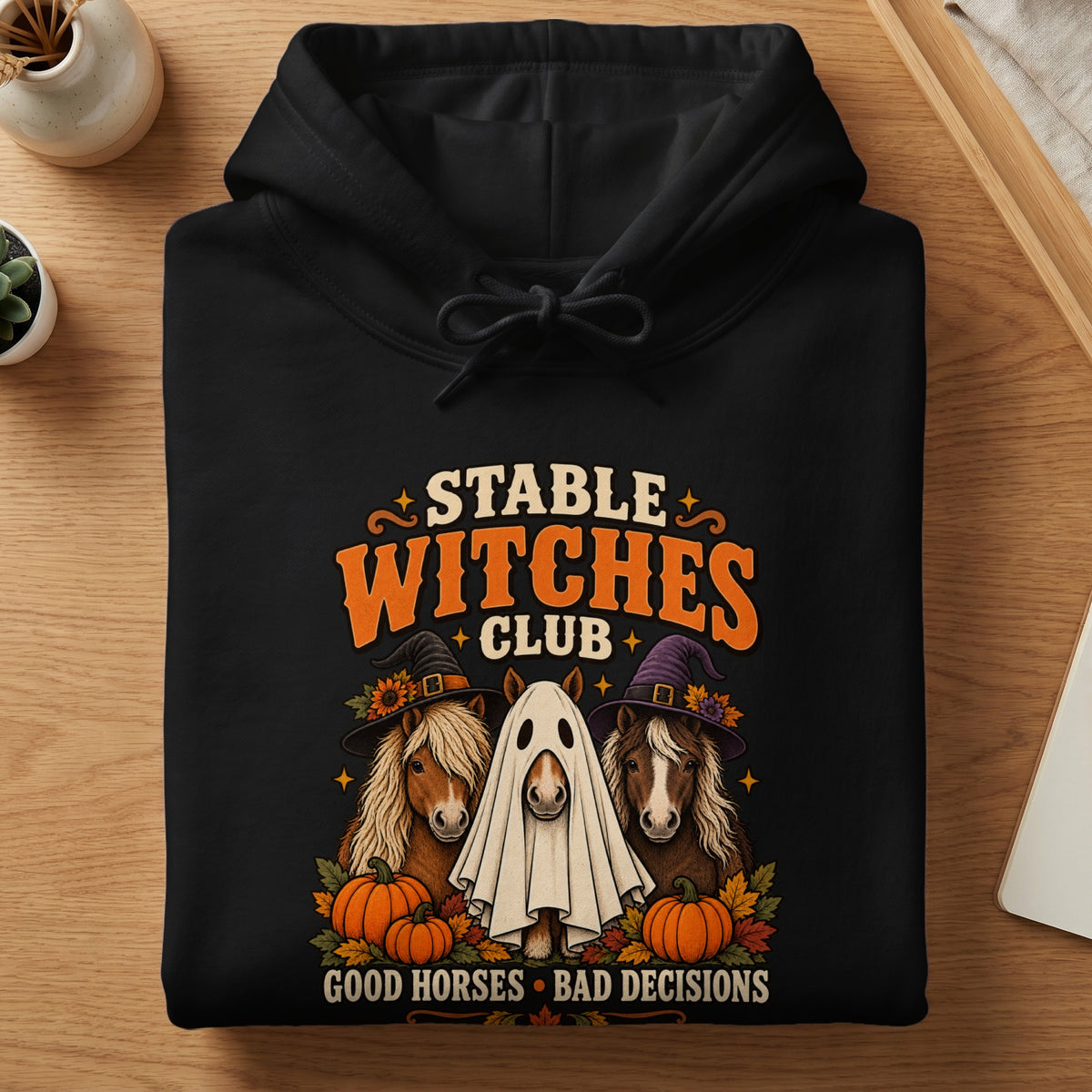 Black hoodie with "Stable Witches Club" text, three horses, and pumpkins.
