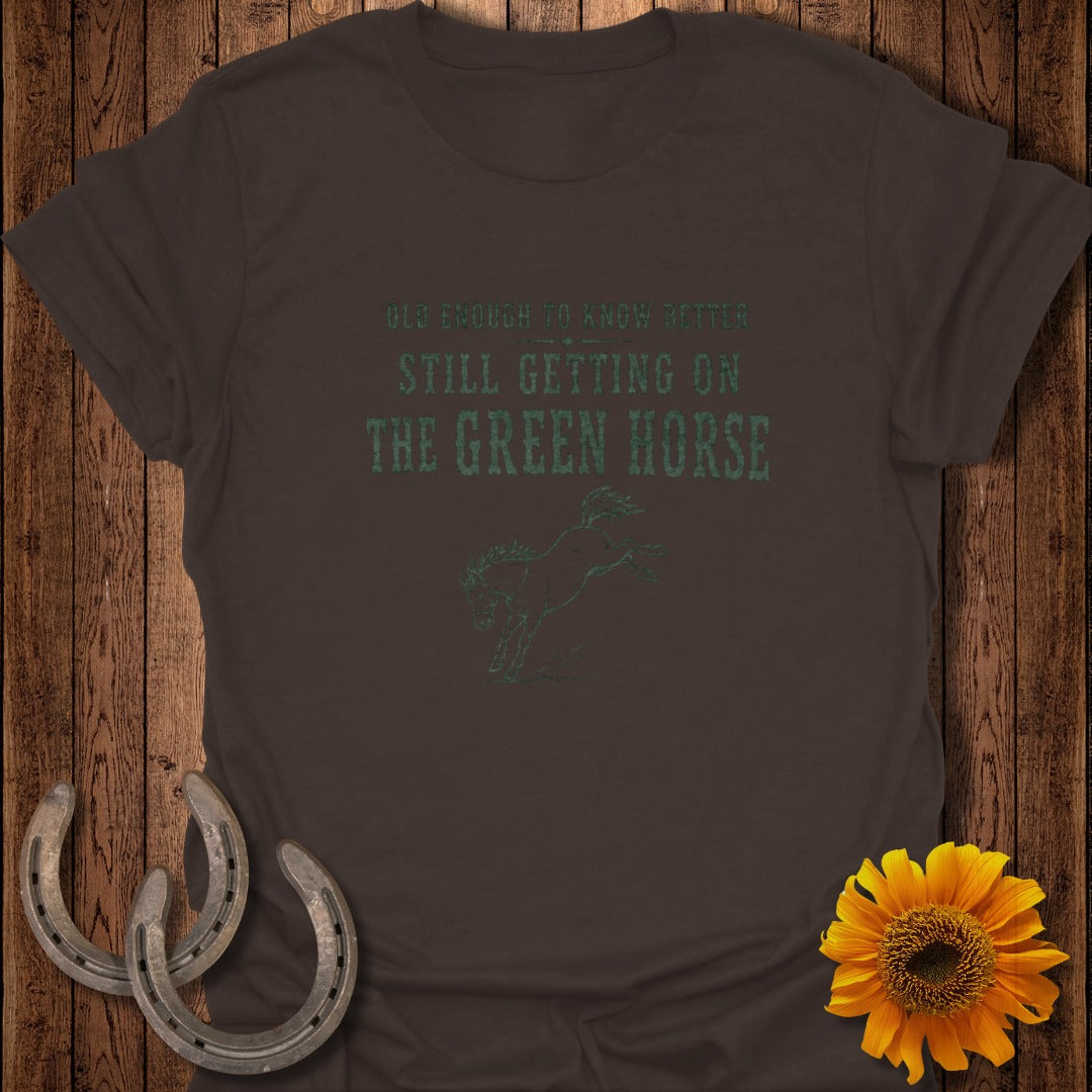 Brown t-shirt with "OLD ENOUGH TO KNOW BETTER STILL GETTING ON THE GREEN HORSE" text and horse graphic.