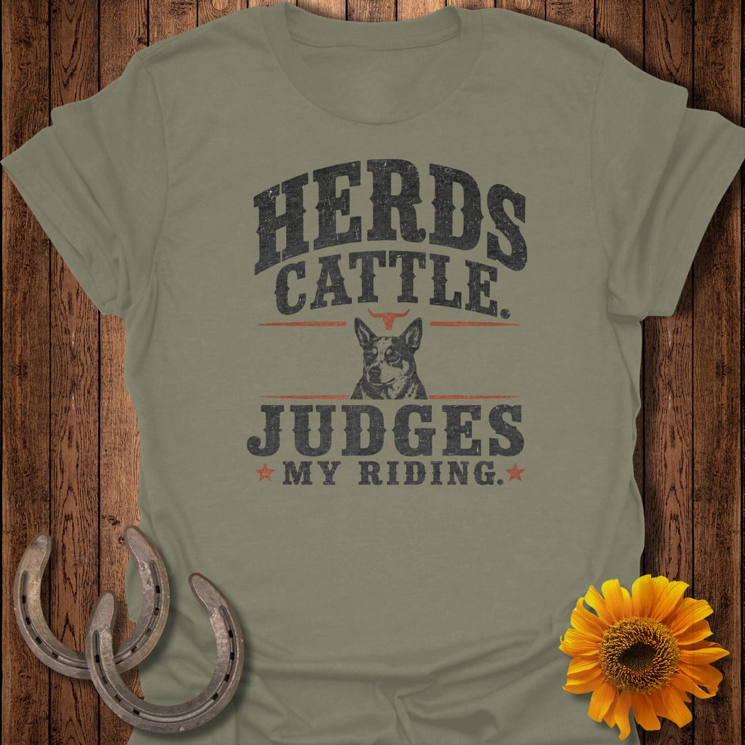 Olive green t-shirt with "Herds Cattle Judges My Riding" text and a dog.