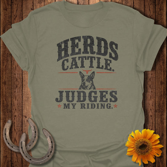 Olive green t-shirt with "Herds Cattle Judges My Riding" text and a dog.
