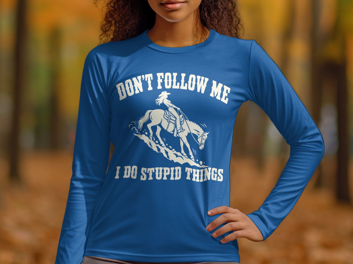 A person wearing a royal blue long-sleeve shirt with a white graphic of a horse and rider and the text Don't follow me I do stupid things.