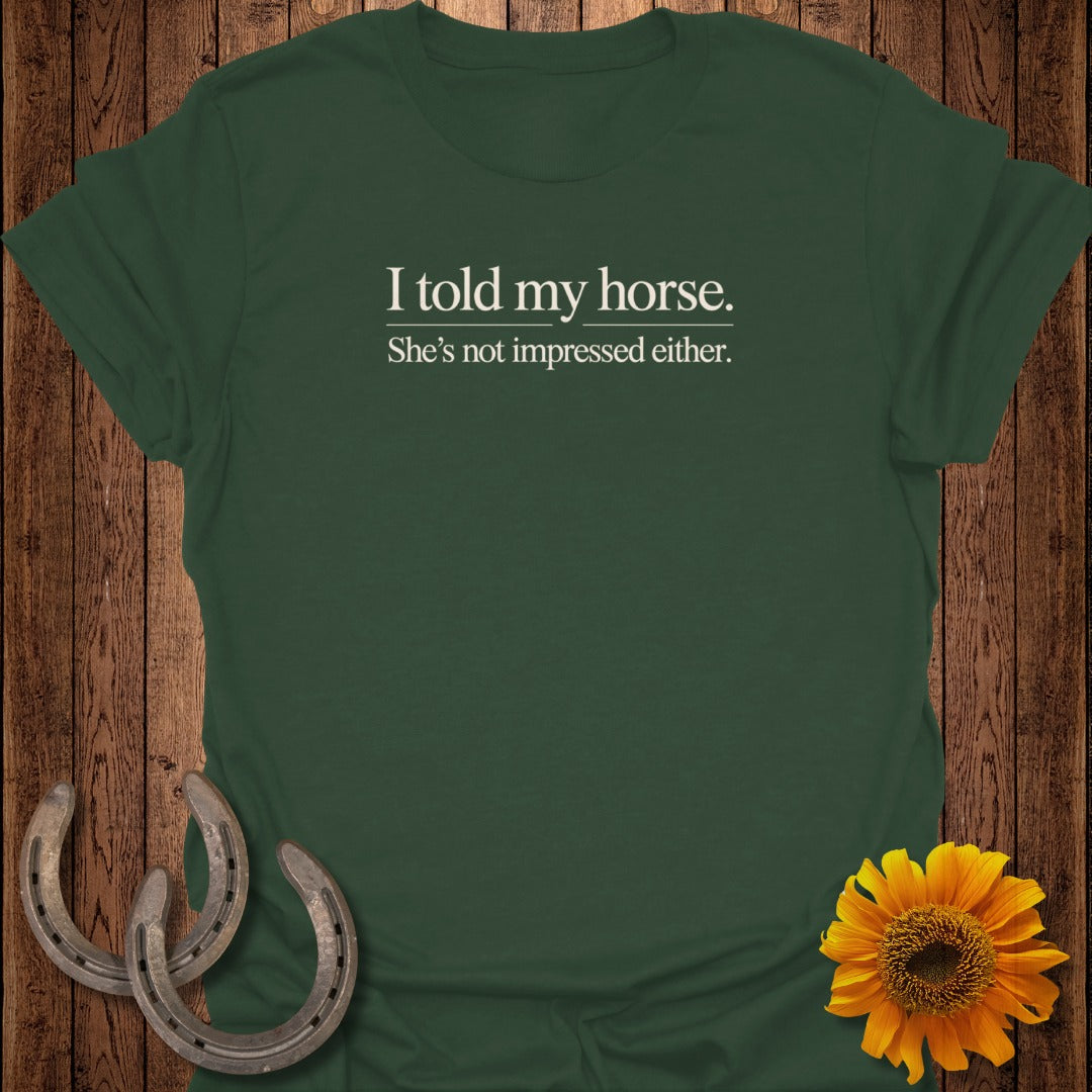 Dark green t-shirt with white text: "I told my horse. She's not impressed either."