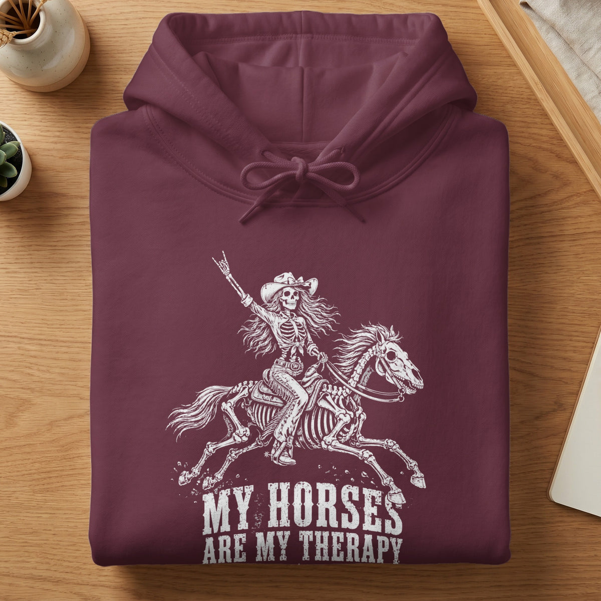 Maroon hoodie with skeleton rider and horse graphic, text reads "MY HORSES ARE MY THERAPY".