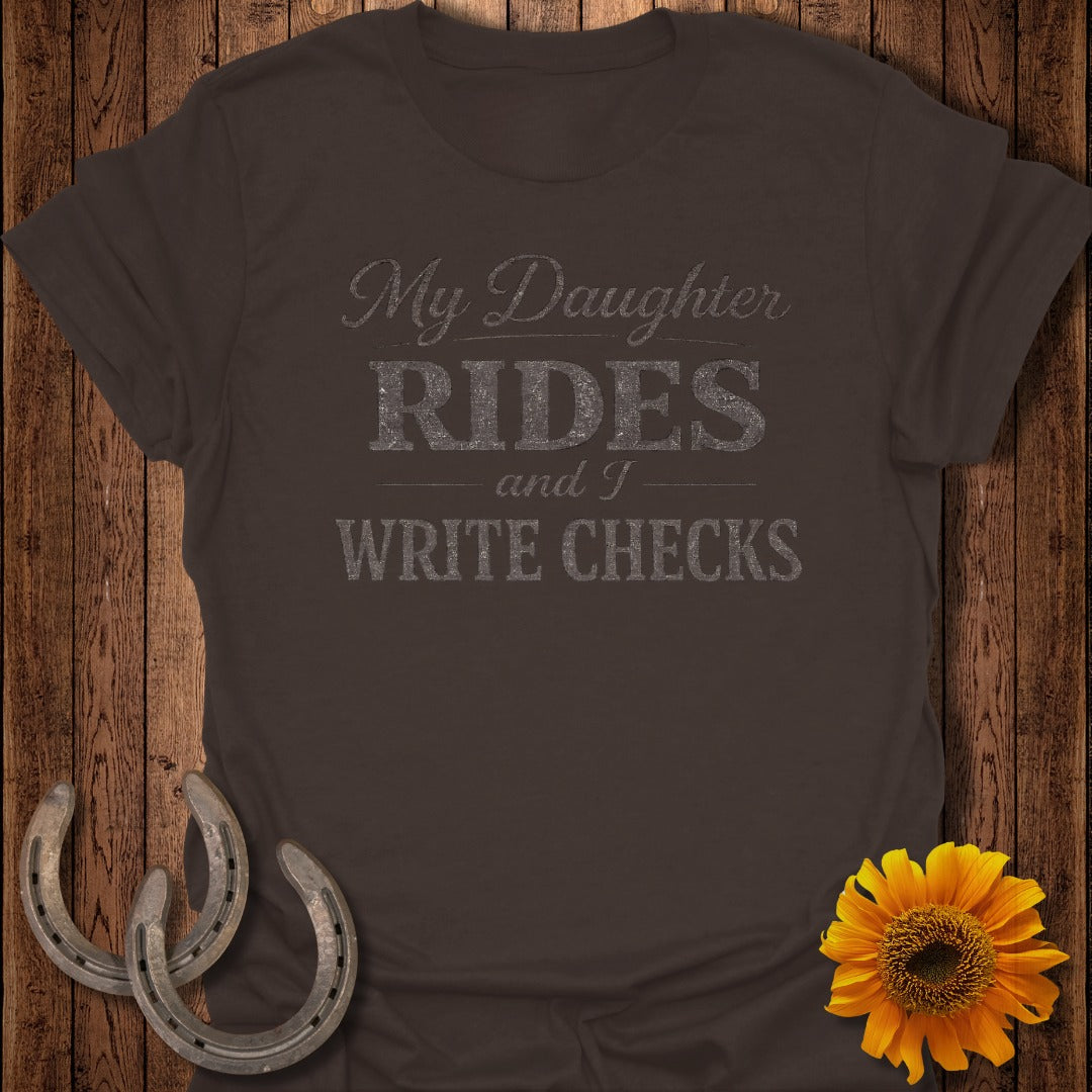 Brown t-shirt with text "My Daughter RIDES and I WRITE CHECKS".