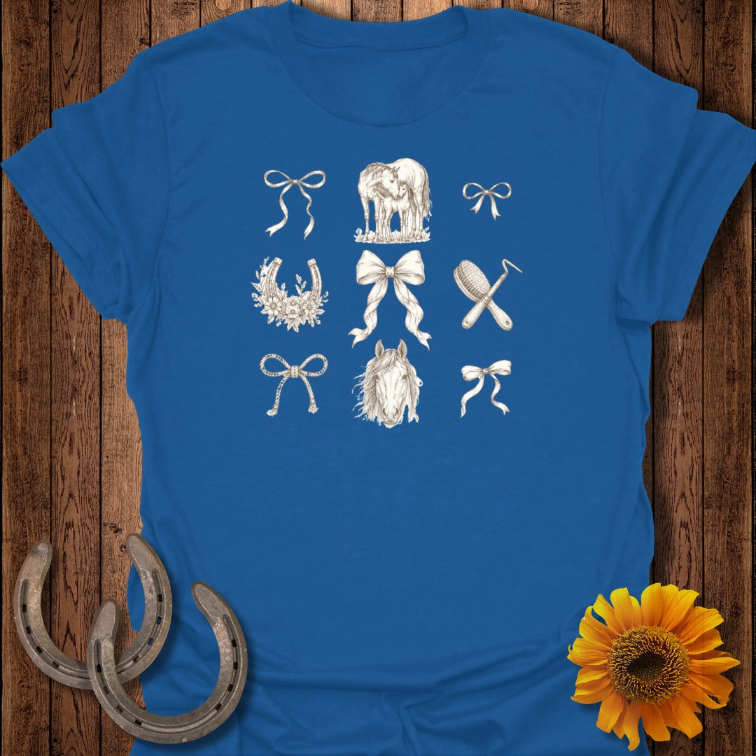 Blue t-shirt with line drawings of horses, bows, and grooming tools.