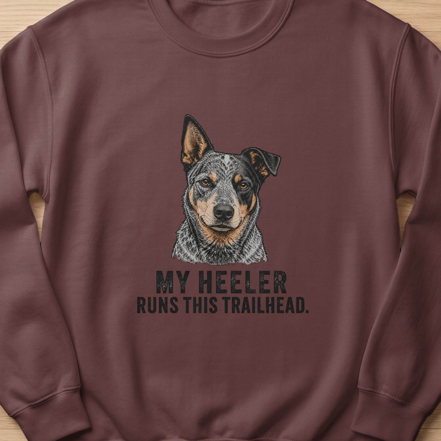 Heeler dog portrait on brown sweatshirt with text "MY HEELER RUNS THIS TRAILHEAD."