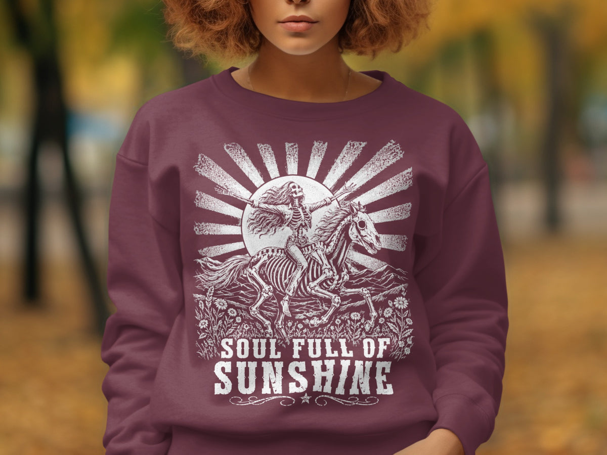 Maroon sweatshirt with skeleton on horse and text "Soul Full of Sunshine."