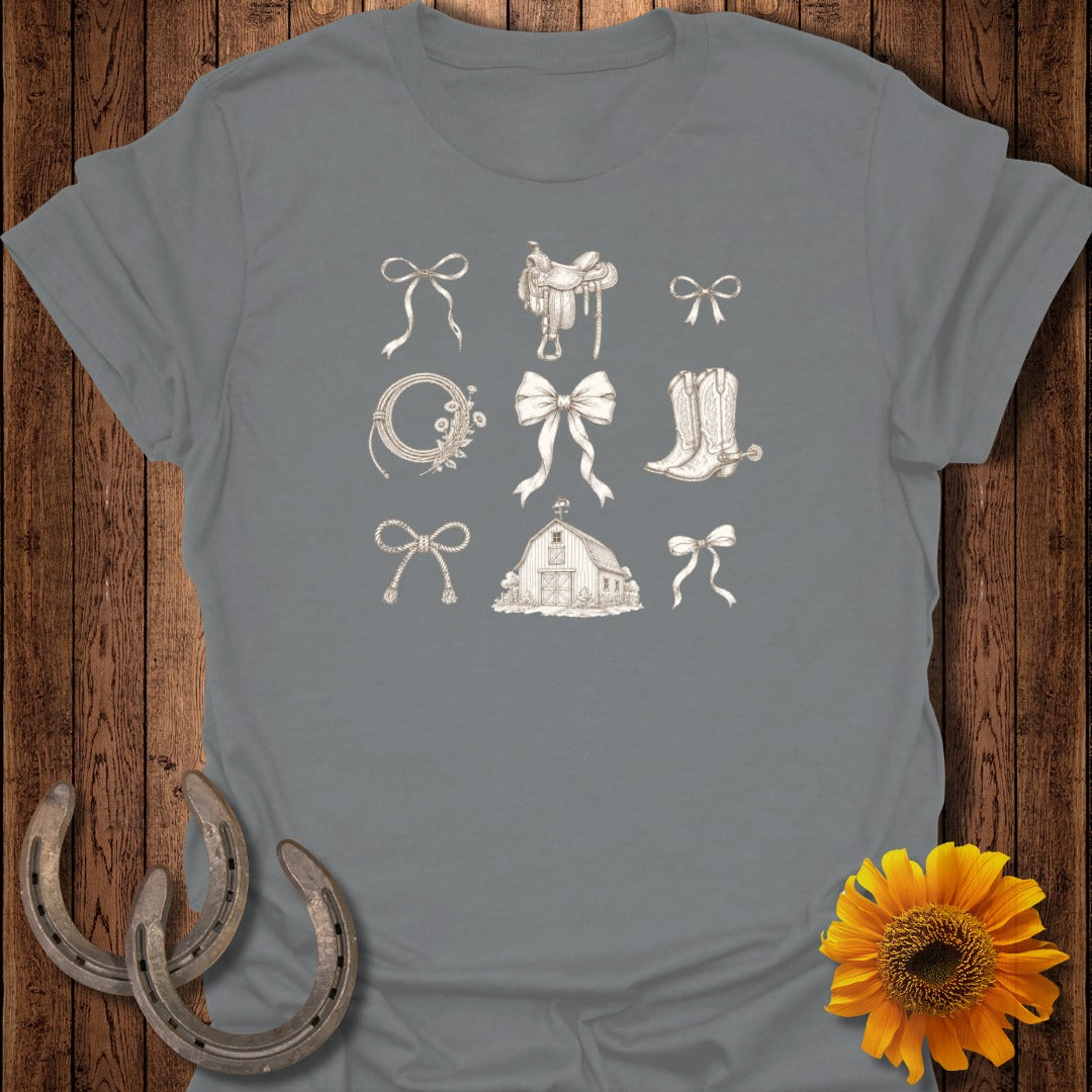 Grey t-shirt with line drawings of bows, a saddle, a barn, and horseshoes.
