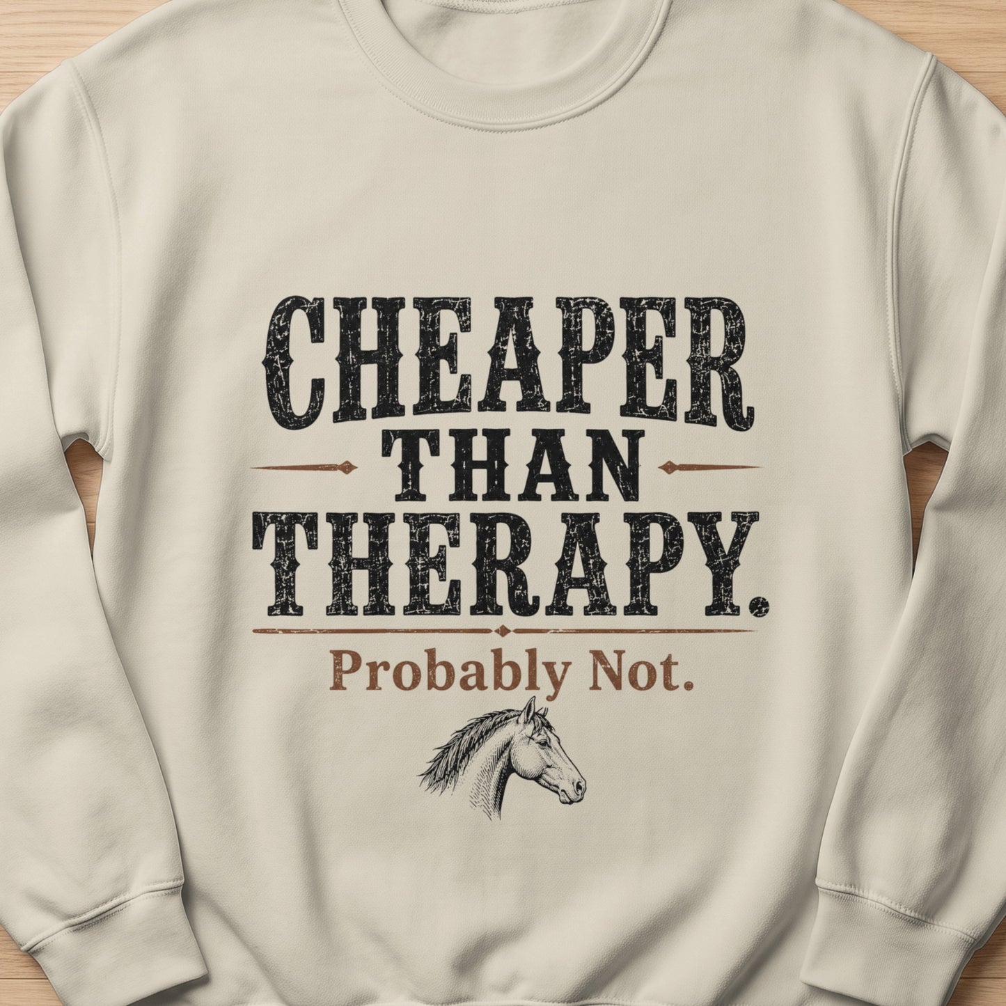 Cream sweatshirt with "Cheaper Than Therapy. Probably Not." text and horse head graphic.