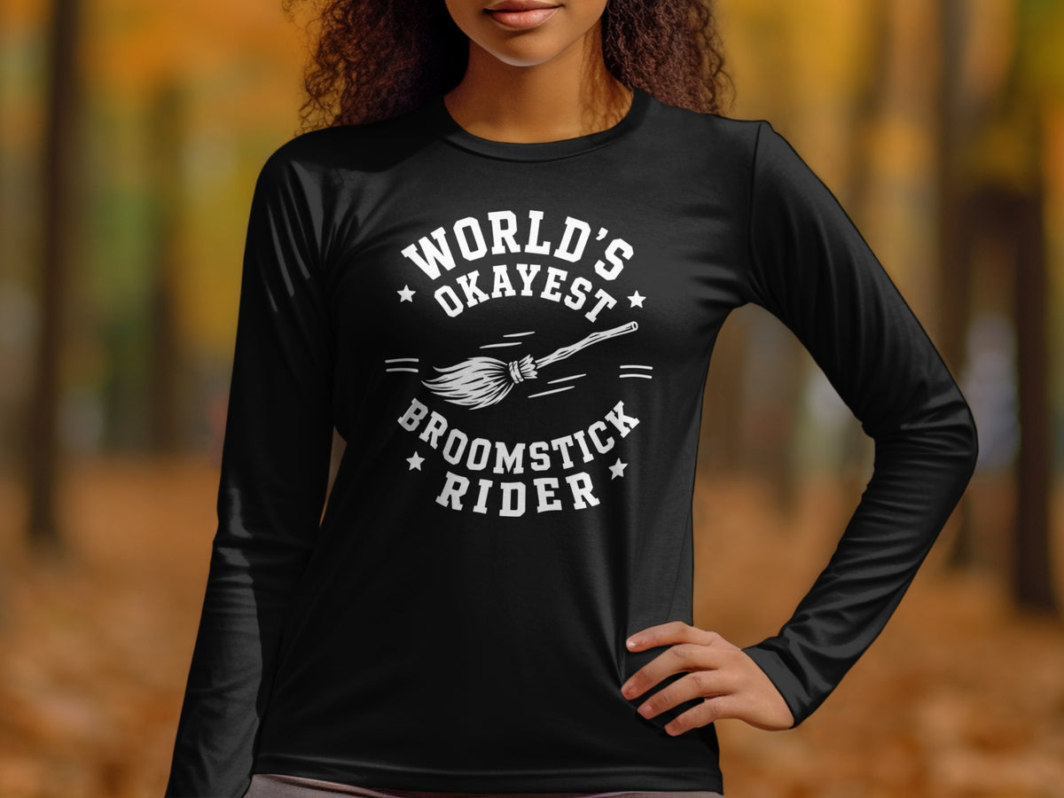 Black long-sleeve shirt with white text "World's Okayest Broomstick Rider" and a broom.