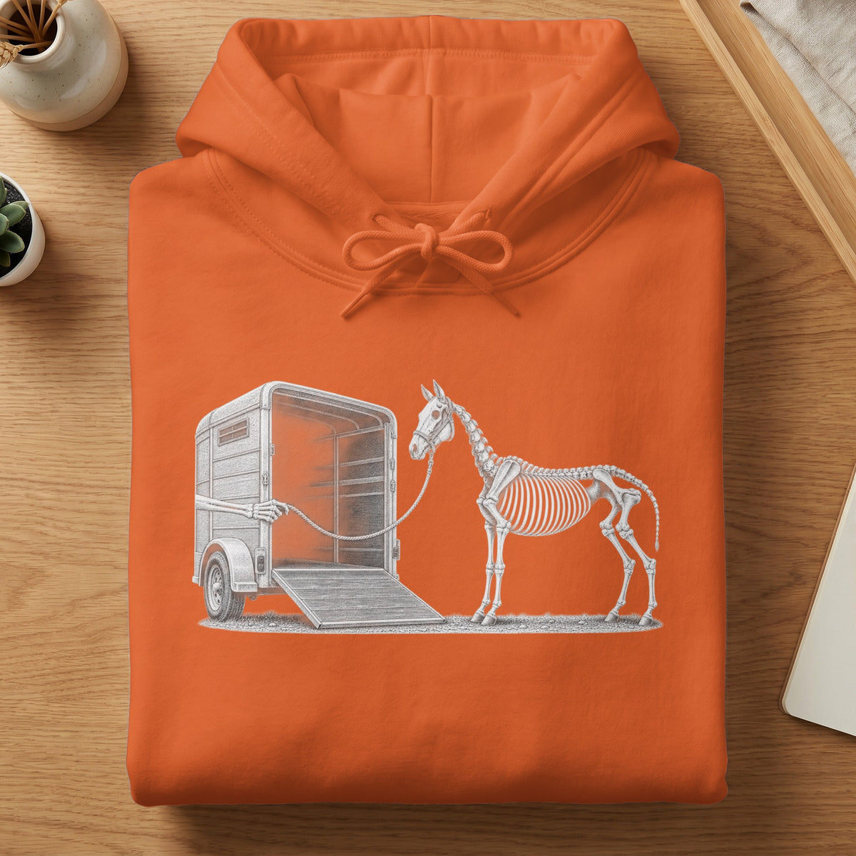 Skeleton horse tied to trailer with rope, illustration on orange hoodie.