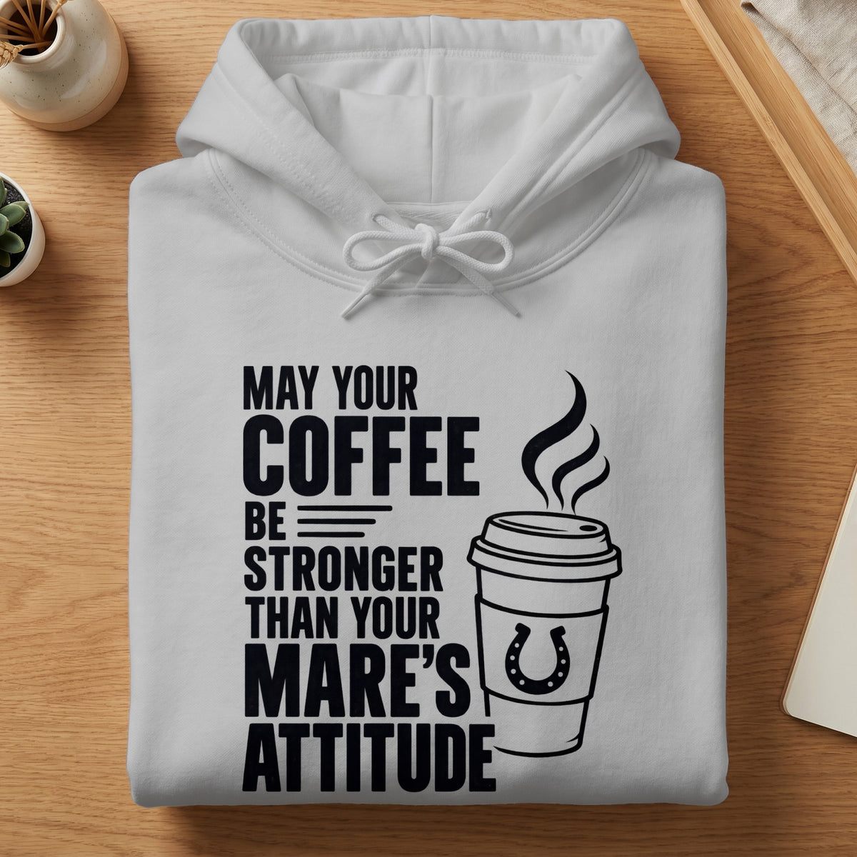 White hoodie with text: "MAY YOUR COFFEE BE STRONGER THAN YOUR MARE'S ATTITUDE" and a coffee cup with a horseshoe.