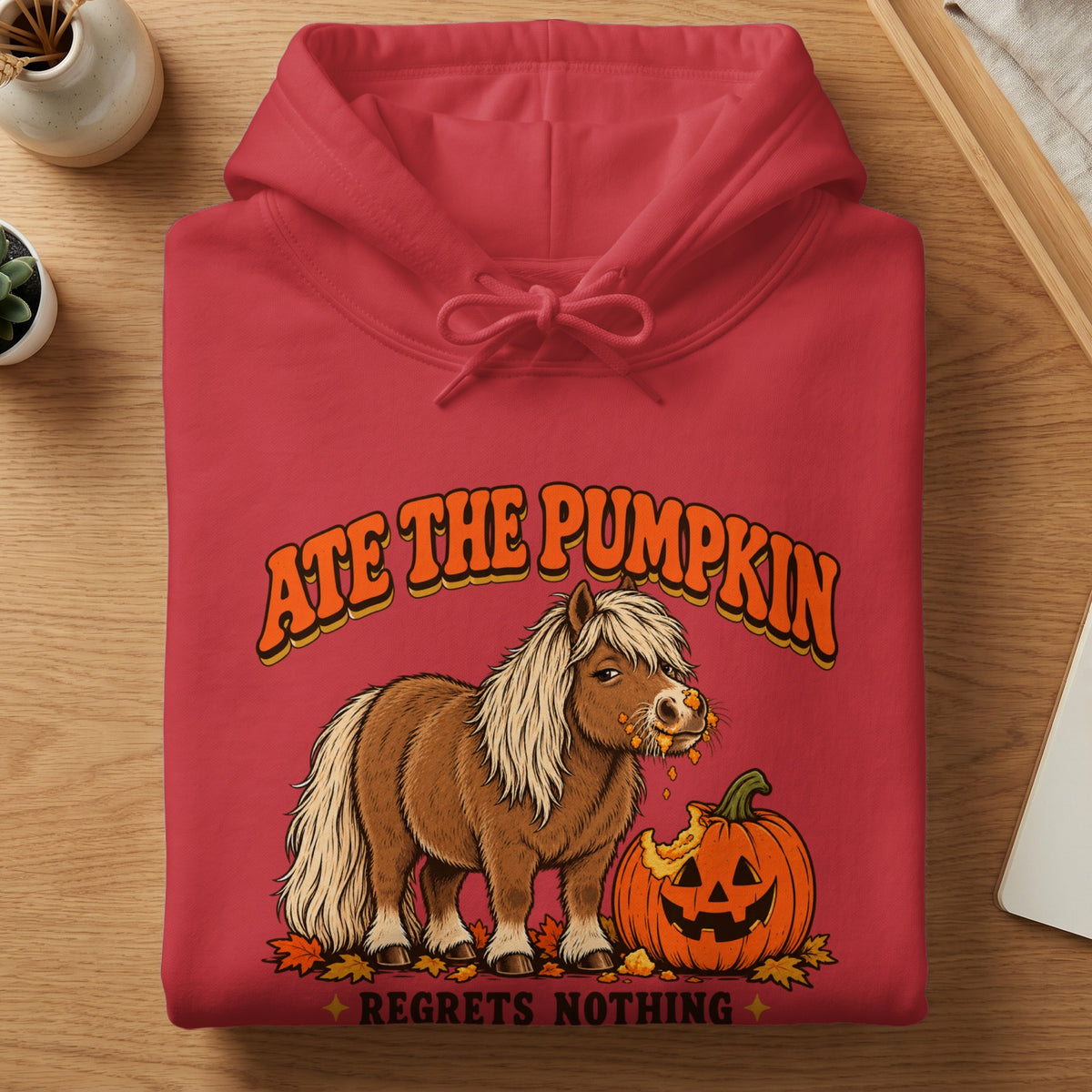 Red hoodie with a graphic of a pony eating a pumpkin, text says "Ate the Pumpkin Regrets Nothing".