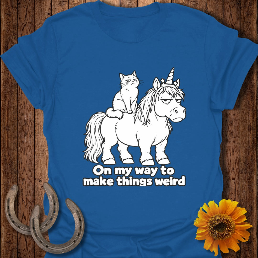 Blue t-shirt featuring a grumpy cat riding an unamused unicorn with the text On my way to make things weird.