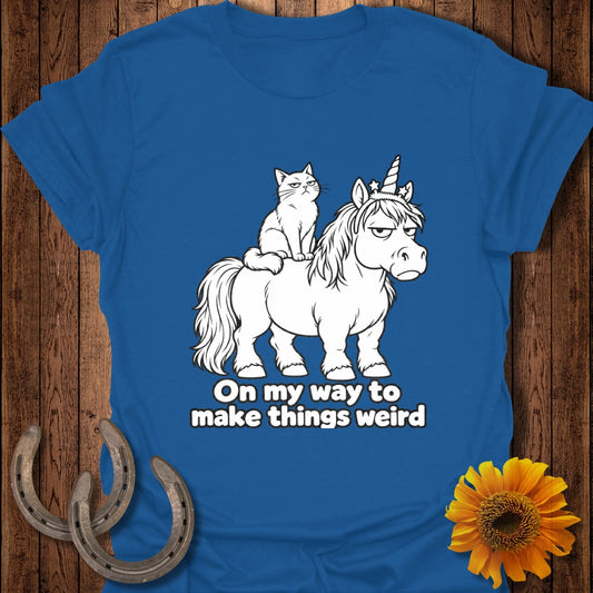 Blue t-shirt featuring a grumpy cat riding an unamused unicorn with the text On my way to make things weird.