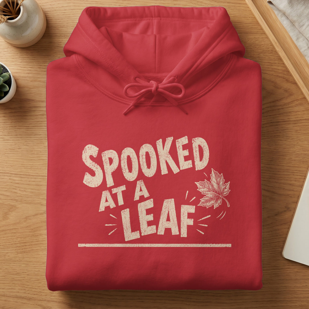Red hoodie with "SPOOKED AT A LEAF" text and a maple leaf graphic.