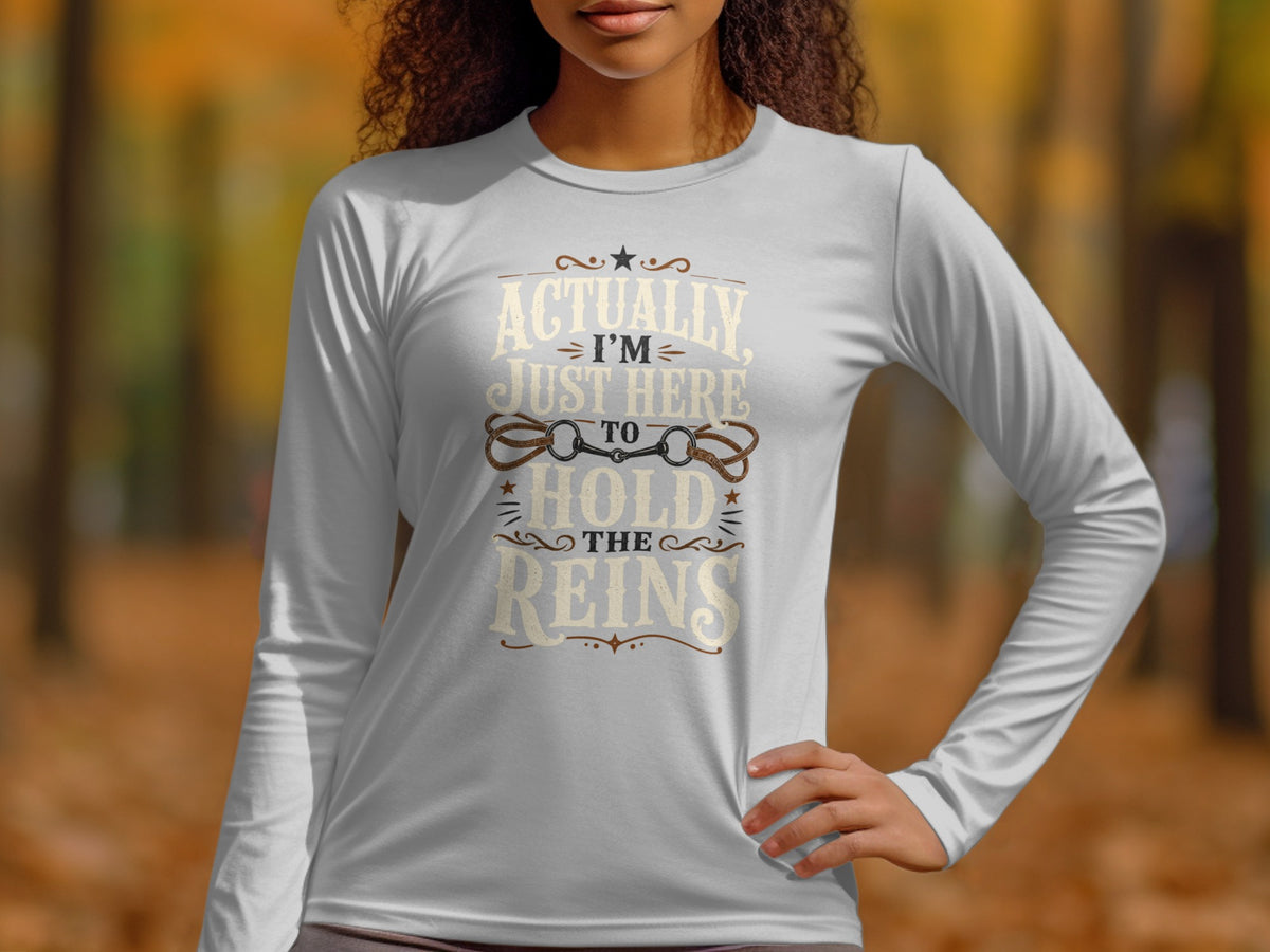 White long-sleeve shirt with "Actually, I'm Just Here to Hold the Reins" text.