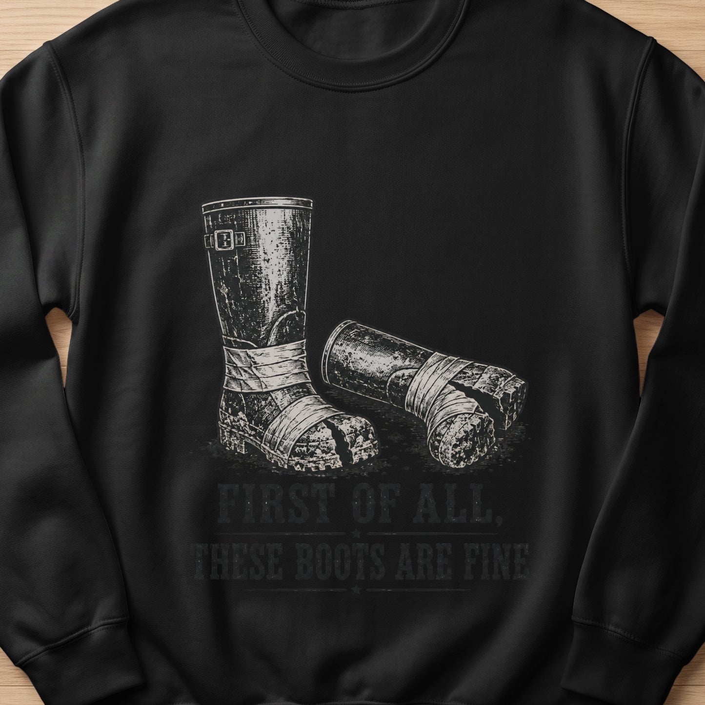 Black sweatshirt with graphic of worn boots and text "First of all, these boots are fine".