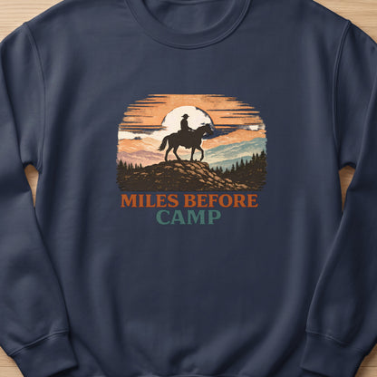 Silhouette of a rider on a horse against a sunset with text "MILES BEFORE CAMP".