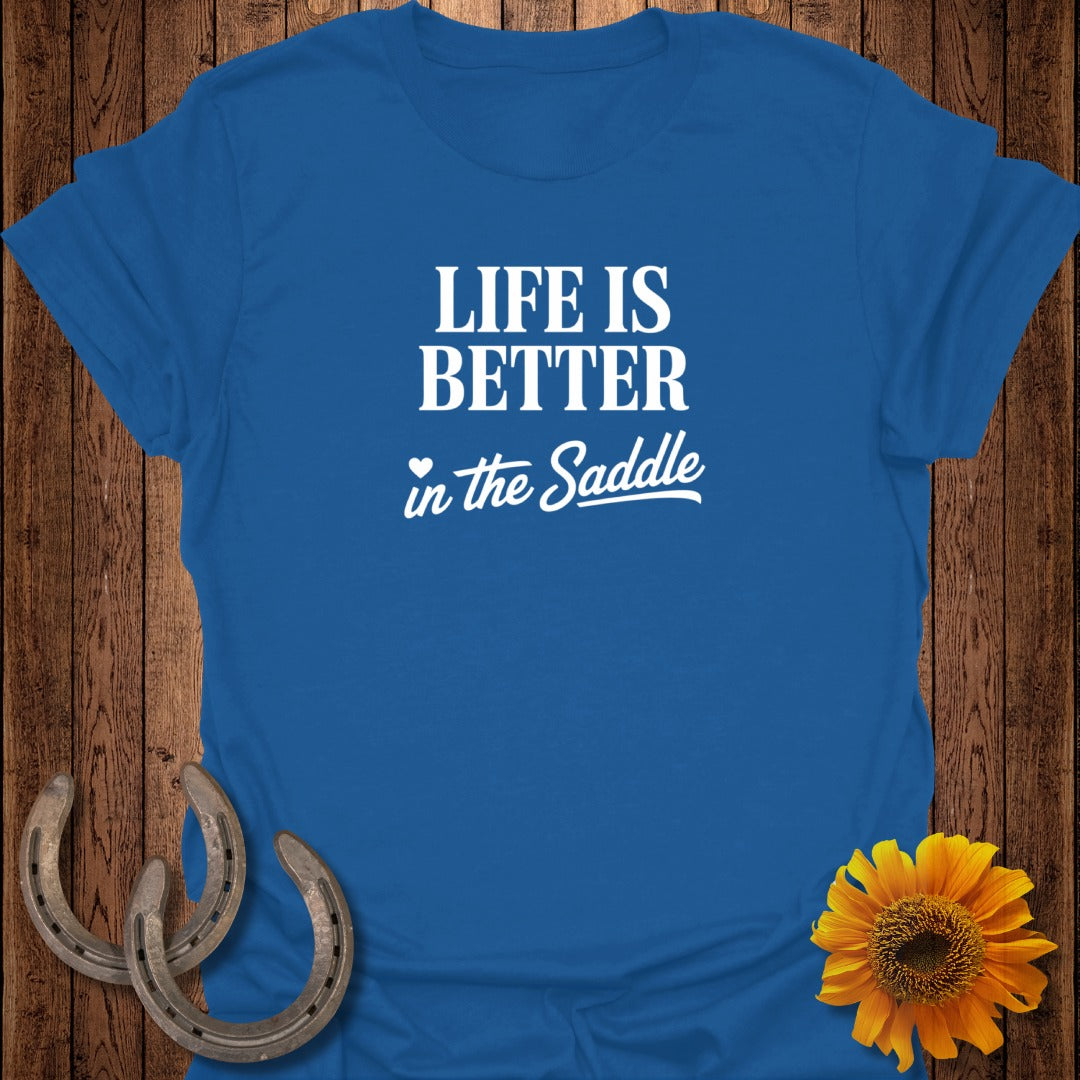 Blue t-shirt with white text "LIFE IS BETTER in the Saddle" and two horseshoes.