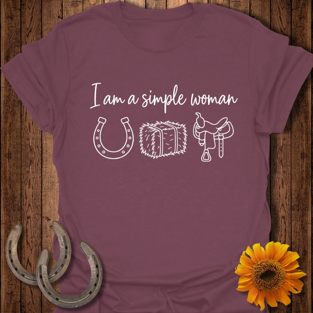 Maroon t-shirt featuring the white text I am a simple woman, a horseshoe, hay bale, and saddle.
