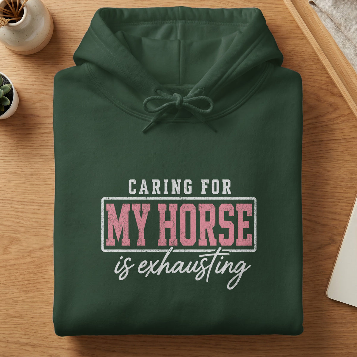 Green hoodie with text "Caring for my horse is exhausting" on the chest.