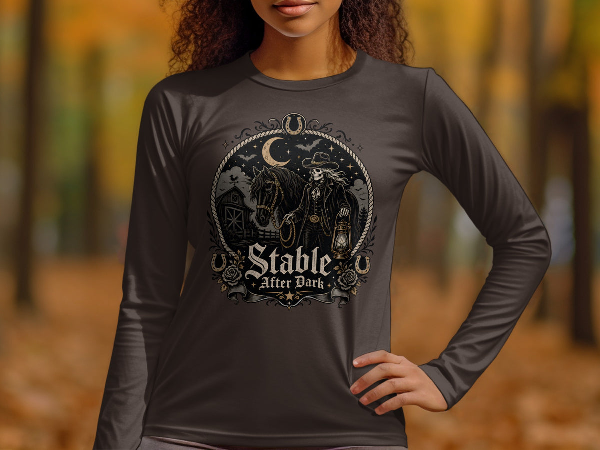 Long sleeve t-shirt graphic with skeleton cowboy, horse, barn, and moon text "Stable After Dark".