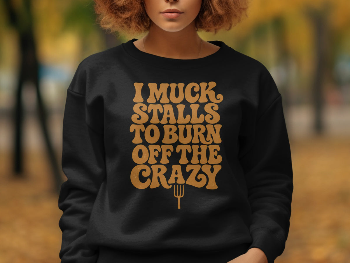Black sweatshirt with "I muck stalls to burn off the crazy" text in brown.