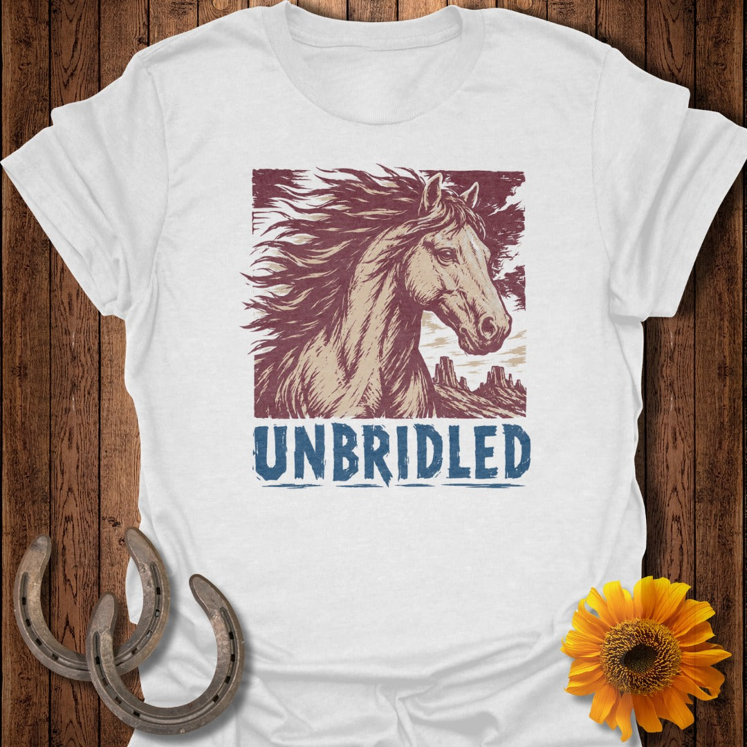 White t-shirt with distressed illustration of a horse and mountains, text "UNBRIDLED".
